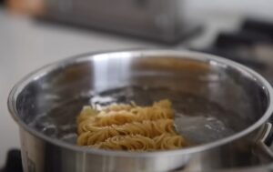 Instant noodles are placed in a pot of boiling water