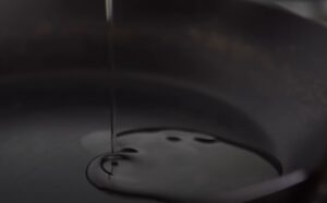 Oil being poured into a hot pan